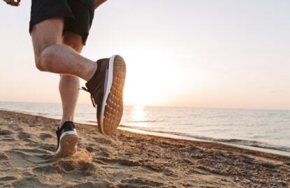 Back view of a sportsmen's legs running on a sand