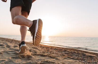 Back view of a sportsmen's legs running on a sand